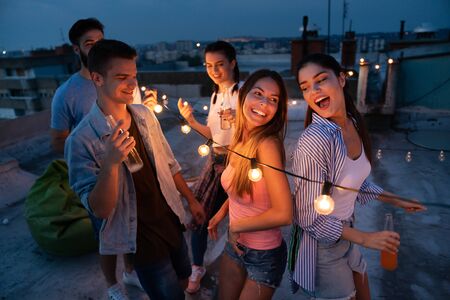 Having a great time with friends, having fun at rooftop partyの写真素材