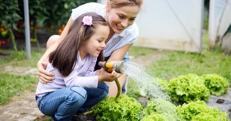 Beautiful happy mother and daughter working in the farm, gardenの写真素材