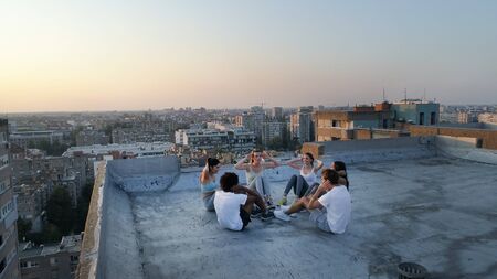 Group of fit healthy friends, people exercising together outdoor on rooftop