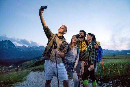Group of young friends hiking in countryside. Multiracial happy people travellingの写真素材