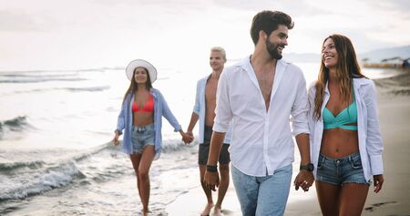 Happy couple in love walking on beach, enjoying summer vacationの写真素材