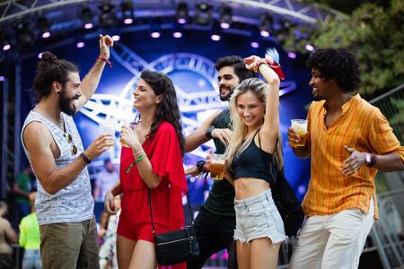 Happy young group of friends attending festivals at summerの写真素材