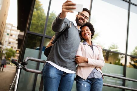 Happy couple having fun and taking a selfie. Smiling people enjoying city life.の写真素材