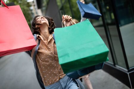 Happy woman with shopping bags enjoying in shopping. Consumerism, shopping, lifestyle conceptの写真素材