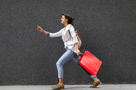 Portrait of young happy smiling woman with shopping bagsの写真素材