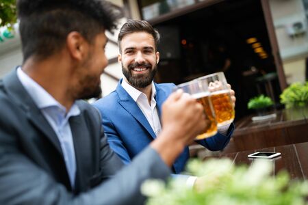 Business people drink beer after work. Businessmen enjoy a beer.の写真素材