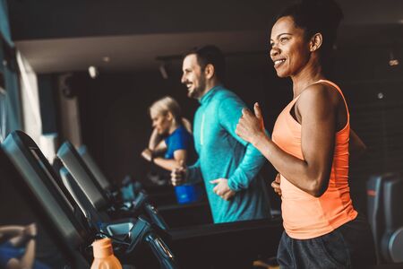 Young people running on a treadmill in modern gymの写真素材