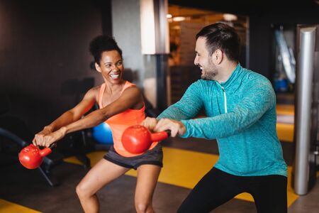 Group of young happy fit people doing exercises in gymの写真素材
