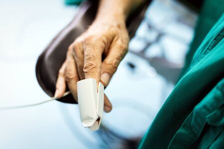 Patient with pulse oximeter on finger for monitoring during surgery in hospitalの写真素材