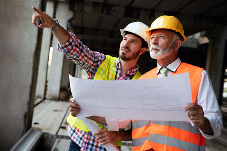 Architect and construction engineer or surveyor discussion plans and blueprintsの写真素材