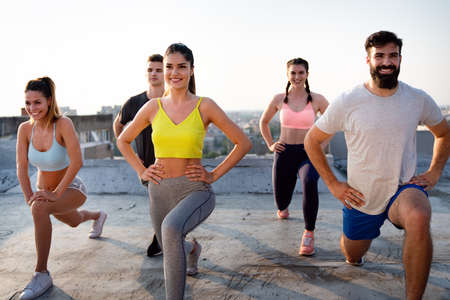 Group of happy fit people friends exercising together outdoorの写真素材