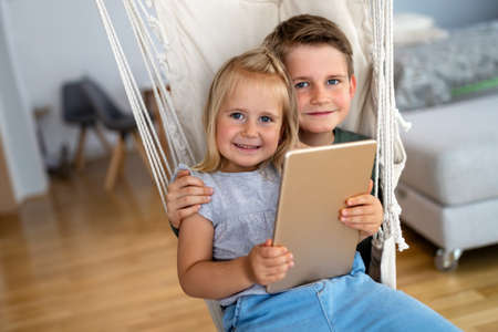 Childhood, technology and family concept. Little kids playing with tablet pc computer