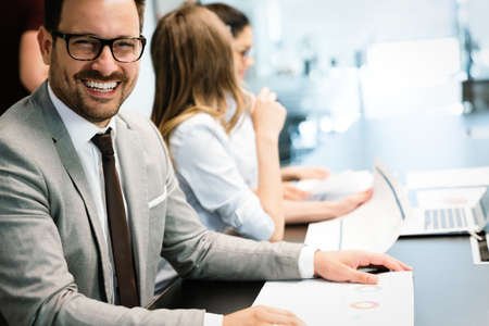 Happy business man with colleagues at a conference in office