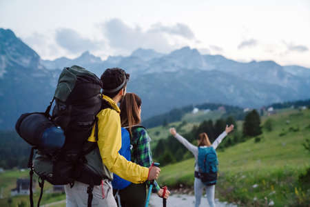 Group of happy friends, people with backpacks hiking together