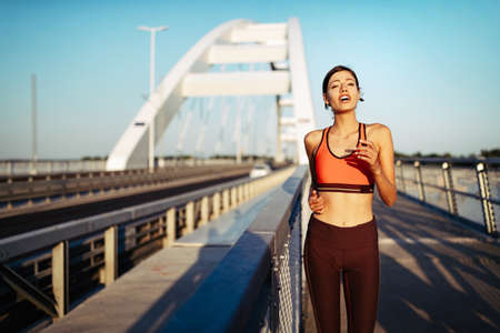 Happy young woman exercising outdoors. Living healthy life