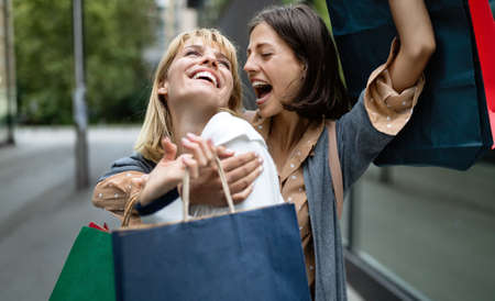Beautiful happy women with shopping bags walking at the mallの写真素材