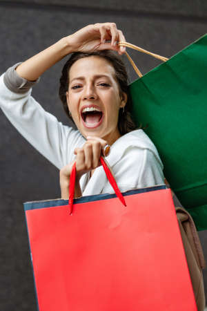 Happy woman with shopping bags enjoying in shopping. Consumerism, shopping, lifestyle conceptの写真素材
