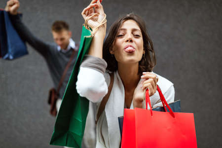 Portrait of beautiful smiling young woman with shopping bagsの写真素材