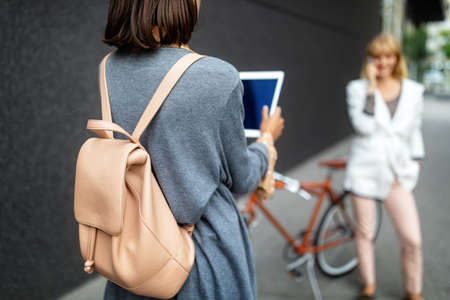 Two happy women are having fun together in the city. Technology, people fun conceptの写真素材