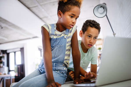 Kids, technology concept. Happy children using laptop to learn, play, fun.