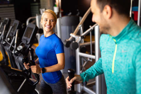Happy people working out on treadmills in the gym