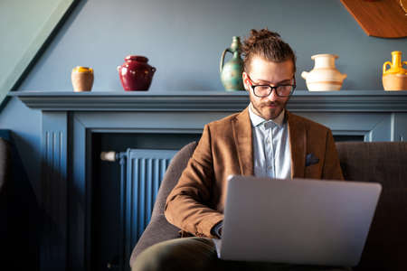 Successful young businessman typing on laptop at workplace