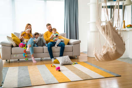 Happy young family spending time together at homeの写真素材