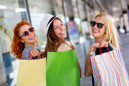 Shopping, fun and tourism concept. Beautiful girls with shopping bags in ctiyの写真素材