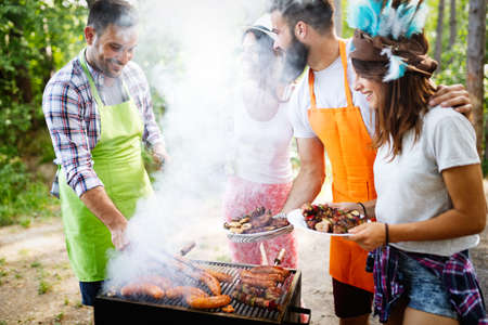 Friends having fun in nature doing bbqの写真素材