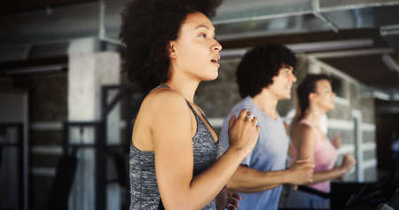 Group of young people exercising on a treadmill at gym