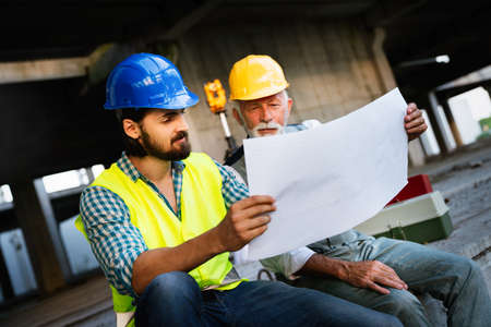 Team of construction engineers, architects working on building site