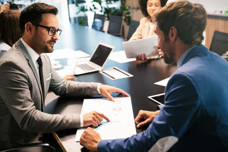 Image of business partners discussing documents and ideas