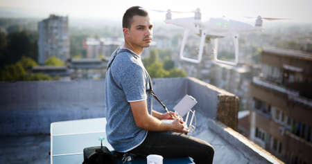 Man with drone flying at the city on rooftop