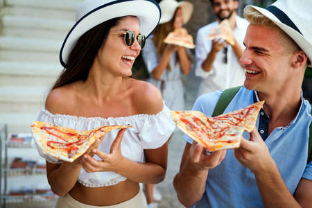 Happy people eating fast food in city while travelling