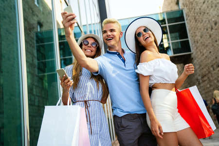 Friends having fun in the city shopping tourism enjoying togetherの写真素材