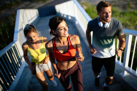 Fitness, sport, people and running concept. Happy fit friends running outdoorsの写真素材