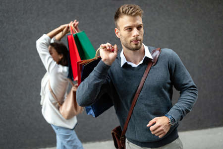 Handsome attractive man smiling shopping in the cityの写真素材