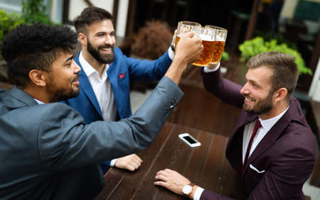 Team of colleagues socializing at the bar and drinking beersの写真素材
