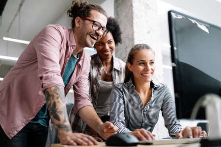 Working together on project. Happy young business colleagues working in officeの写真素材