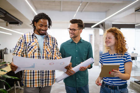 Successful group of designers, business people at work in office