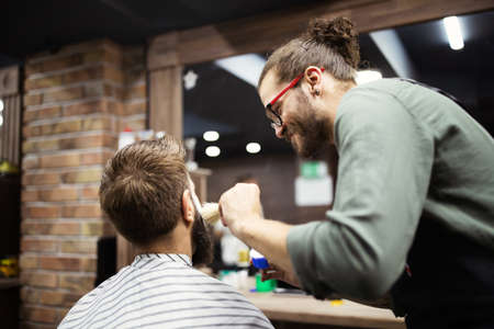 Client during beard shaving in barber shopの写真素材