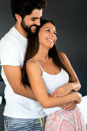 Romantic happy young couple relaxing, hugging at modern home