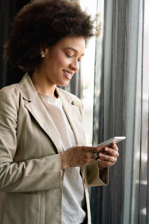 Portrait of a successful business woman using phone in officeの写真素材