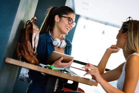 Group of happy college students studying at campus library togetherの写真素材