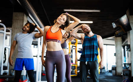 Happy fit friends exercising, working out in gym to stay healthy togetherの写真素材
