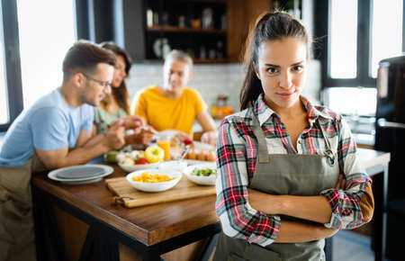 Group of happy friends having fun in kitchen, cooking food together