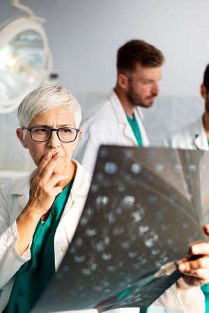 Group of doctors examining an x-ray in hospital to make diagnosisの写真素材