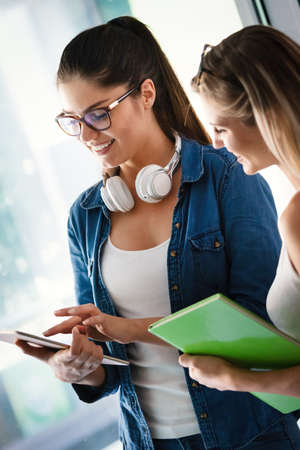 Education concept. University students preparing for exam, talking in libraryの写真素材