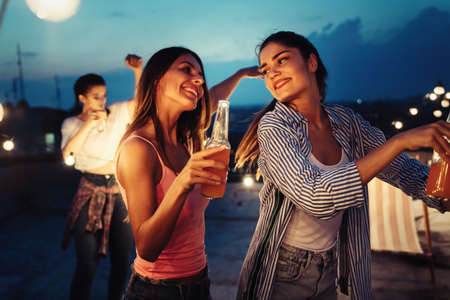 Group of happy friends having party on rooftop
