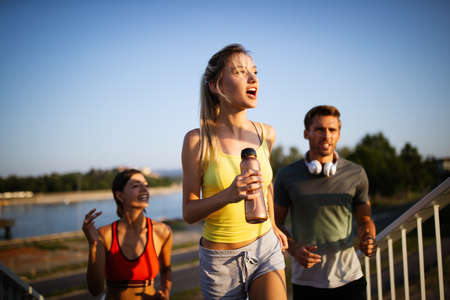 Athletic fit people exercising and running together outdoorsの写真素材